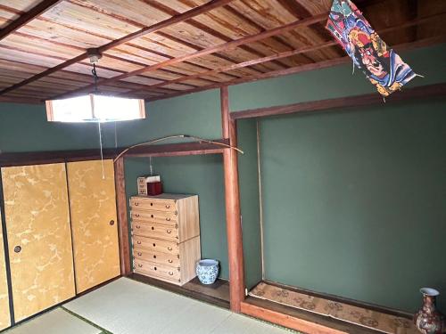 a room with a green wall and a ceiling at ポートサイドSasebo藤原町 in Sasebo