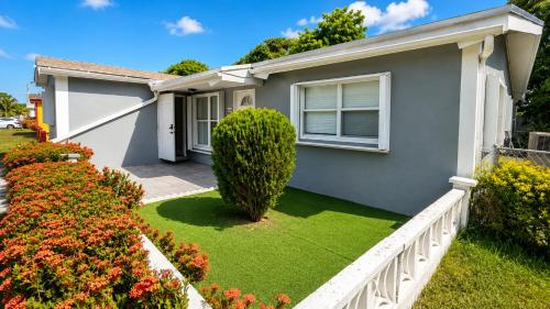 a house with a green lawn in front of it at Private Guest Suite with Separate Entrance & Kitchen in Lauderdale Lakes