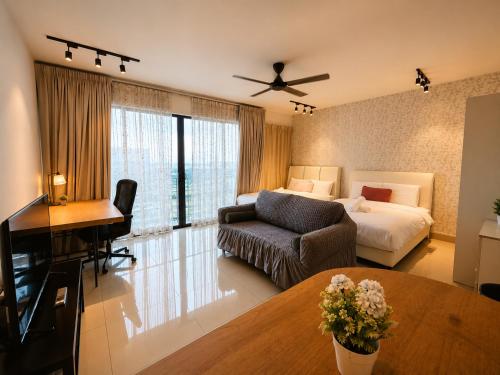 a hotel room with a bed and a couch and a desk at Minimalist Studio Trefoil Setia Alam linked bridge to Mall and Convention Centre near to NIH Peninsula in Setia Alam