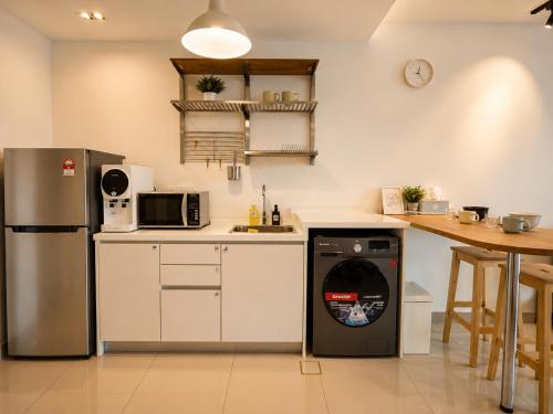 a kitchen with a refrigerator and a dishwasher at Minimalist Studio Trefoil Setia Alam linked bridge to Mall and Convention Centre near to NIH Peninsula in Setia Alam