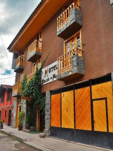a building with orange doors and windows on a street at hostal Balcon de Piedra in Urubamba