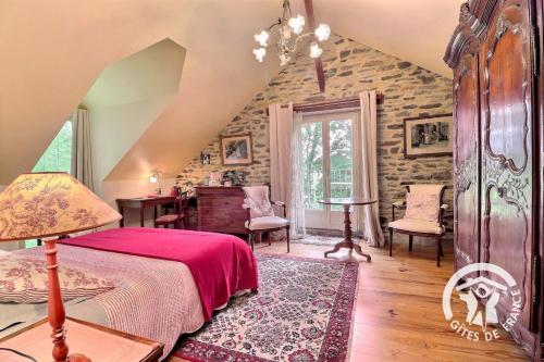 a bedroom with a bed and a table and chairs at Le moulin de blochet in Saint-Erblon