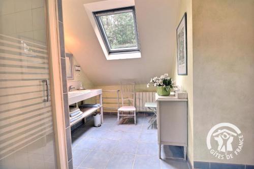 a small bathroom with a sink and a table at Le moulin de blochet in Saint-Erblon
