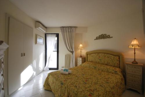 - une chambre avec un lit et une porte donnant sur une terrasse dans l'établissement 1 Bedroom Apartment - Les Jardins de la Croisette, à Cannes