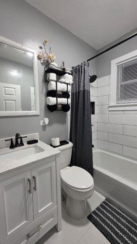 a bathroom with a toilet and a sink and a tub at Peabody short term rental in Staunton