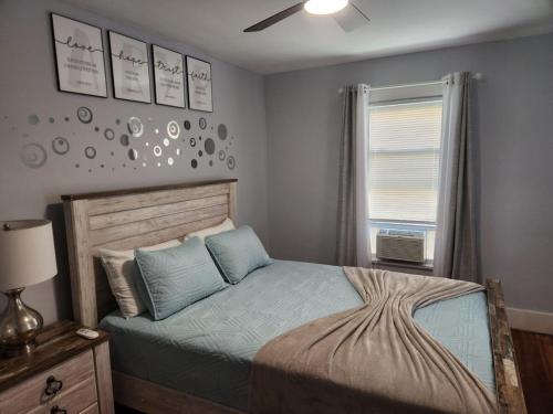 a bedroom with a bed with blue pillows and a window at Peabody short term rental in Staunton