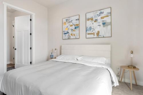 a bedroom with a white bed with two pictures on the wall at La Dolce Vita in Egg Harbor
