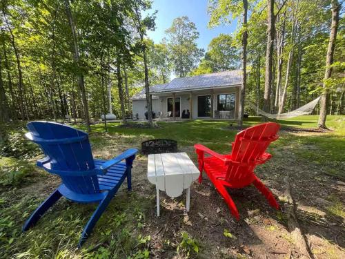 three chairs and a table in front of a house at Stonehedge View by Simple Life Rentals in Egg Harbor
