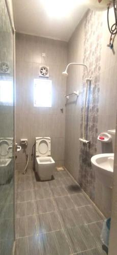 a bathroom with a toilet and a sink and a shower at شاليه السكون AL Sukun Chalet in Al Ḩadd