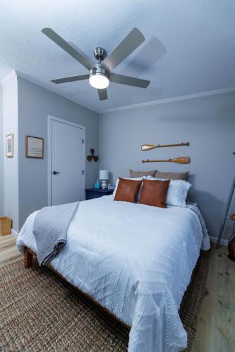 a bedroom with a bed with a ceiling fan at The Roost by Simple Life Rentals in Baileys Harbor