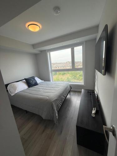a bedroom with a bed and a large window at Oakville Townhouse Amazing Rooftop in Oakville