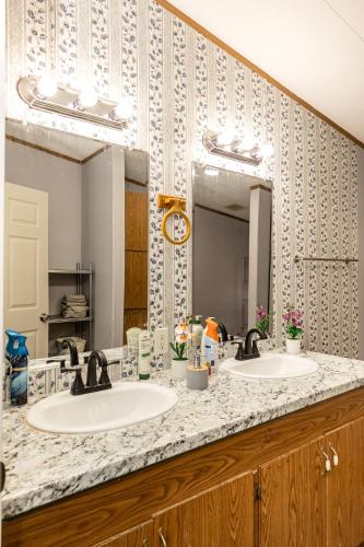 a bathroom with two sinks and a large mirror at The Hidden Creek Hideaway in Huntsville