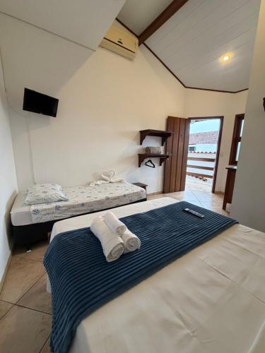 a bedroom with two beds with towels on the bed at Cantinho Centro Histórico in Paraty