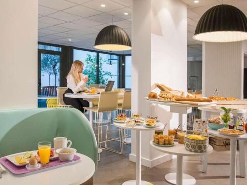 a woman sitting at a table with breakfast food at Ibis Styles Nice Centre Gare in Nice