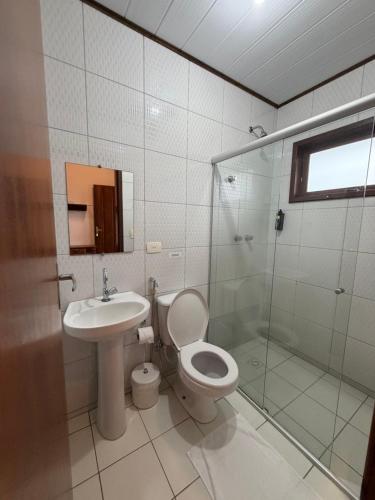 a bathroom with a toilet and a sink and a shower at Cantinho Centro Histórico in Paraty