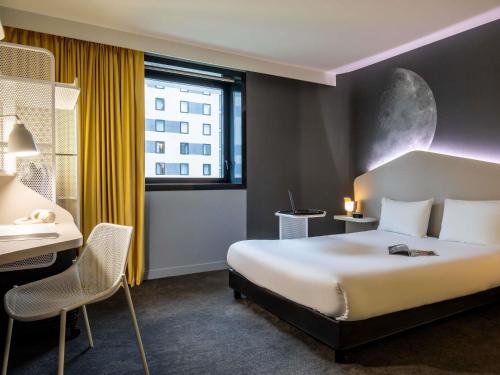 a hotel room with a bed and a desk and a window at ibis Styles Paris Charles de Gaulle Airport in Roissy-en-France