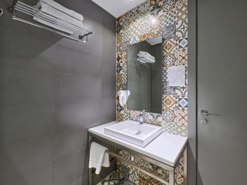 a bathroom with a sink and a mirror at Ibis Styles Dubai Jumeira in Dubai