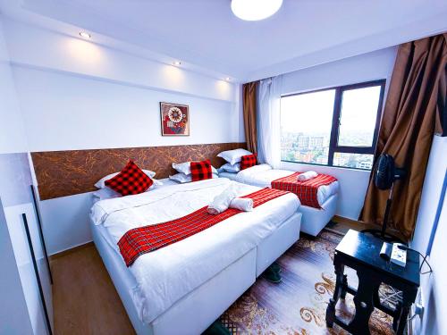 a hotel room with two beds and a window at SPOTLESS HOSTEL, WESTLANDs Orc in Nairobi