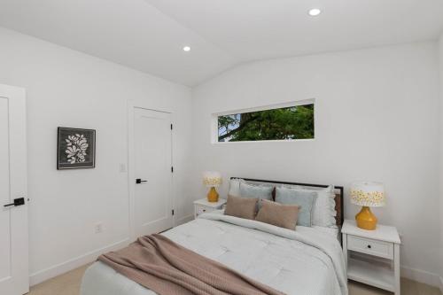 a white bedroom with a bed and two night stands at Modern House in Seattle in Seattle