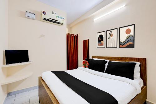 a bedroom with a bed and a tv on a wall at Hotel O Parthasarathyswamy Temple Formerly RKH Inn in Chennai