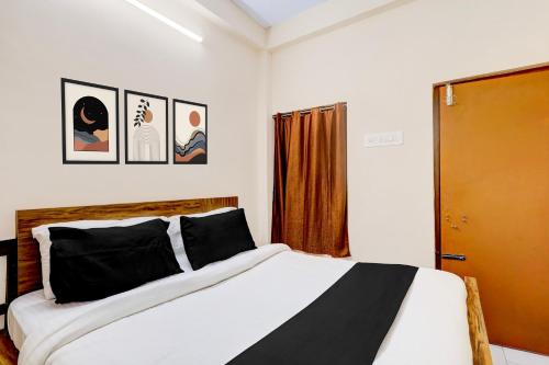 a bedroom with a bed with black and white sheets at Hotel O Parthasarathyswamy Temple Formerly RKH Inn in Chennai