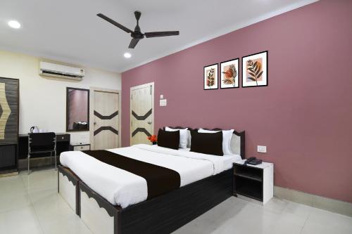 a bedroom with a large bed with a purple wall at Super Collection O Kalighat Metro Station Formerly RM Guest Home in Ālīpur