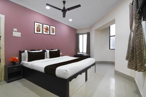 a bedroom with a large bed with a purple wall at Super Collection O Kalighat Metro Station Formerly RM Guest Home in Ālīpur