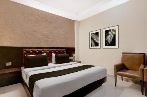 a bedroom with a large bed and a chair at Collection O Haridwar Railway Station Formerly Le Central in Haridwār