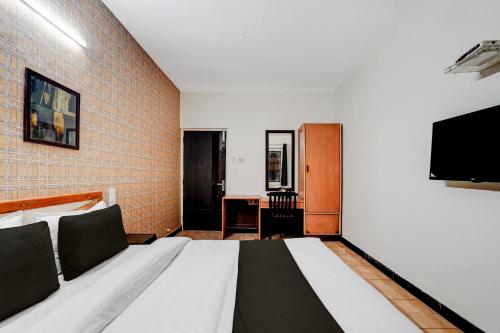 a hotel room with a bed and a television at Super Hotel O by OYO Clock Tower Ludhiana Formerly Greatwall in Ludhiana