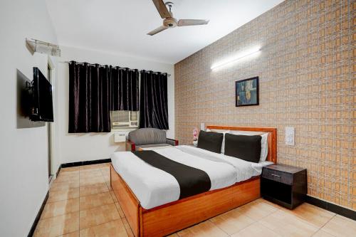 a bedroom with a bed and a tv and a brick wall at Super Hotel O by OYO Clock Tower Ludhiana Formerly Greatwall in Ludhiana