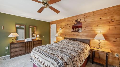 a bedroom with a bed and a wooden wall at Arena by AvantStay in North Creek