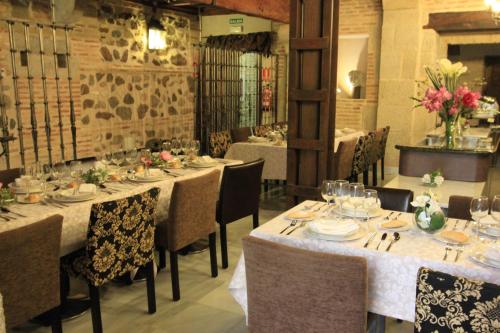a dining room with long tables and chairs and flowers at Pintor El Greco in Toledo