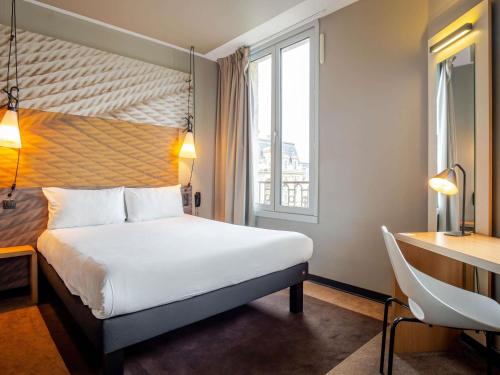 a hotel room with a bed and a desk and a window at ibis Bordeaux Centre Gare Saint Jean Euratlantique in Bordeaux