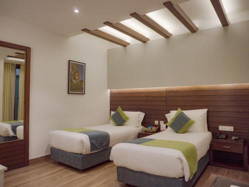 a hotel room with two beds and a mirror at Hotel Icon in Chandīgarh