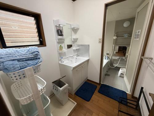 a bathroom with a sink and a shower and a mirror at Hana88 in Otsu