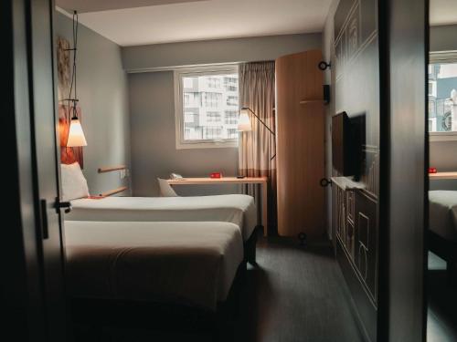 a hotel room with two beds and a window at ibis Lima Reducto Miraflores in Lima