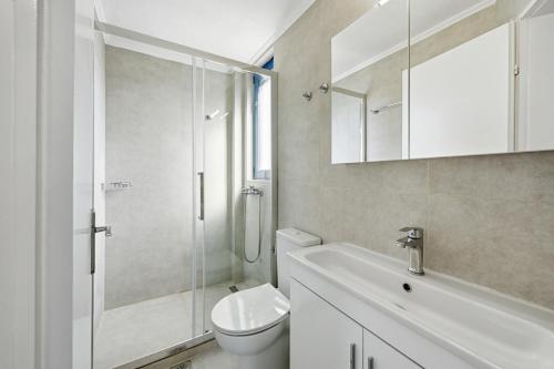 a bathroom with a toilet and a sink and a shower at The Garden Maisonette in Gouvia