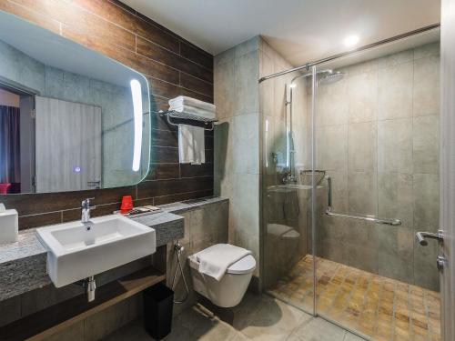 a bathroom with a toilet and a sink and a shower at Ibis Melaka in Malacca
