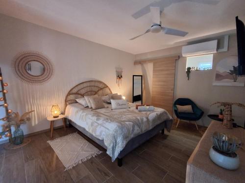 a bedroom with a large bed and a ceiling fan at La Parenthèse 2 Rêves in Saint-Joseph