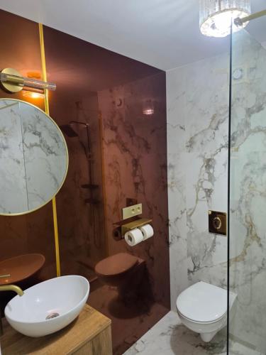 a bathroom with a toilet and a glass shower at Sky deluxe apartment in Giurgiu