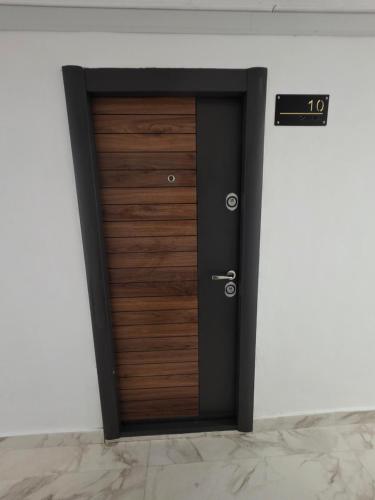 a wooden door in a room with a sign at Sky deluxe apartment in Giurgiu
