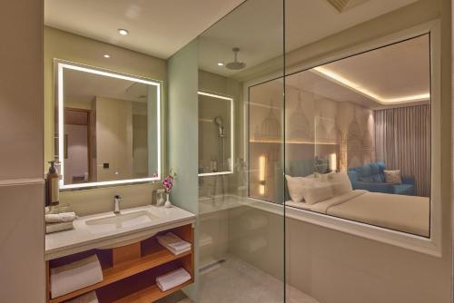 a bathroom with a sink and a mirror at Regenta Devarayah Tirupati in Tirupati