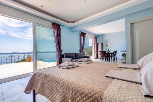 a bedroom with a large bed with a view of the ocean at Daniella with Seaview Pool in Nisaki