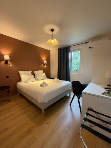 a bedroom with a bed and a desk and a window at Le Moulin de Barette - Blavozy, 43700 Le Puy-en-Velay in Blavozy
