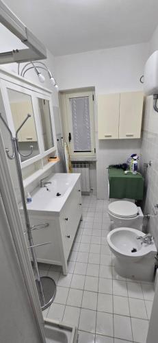 a white bathroom with a toilet and a sink at Villa Margherita in Maratea