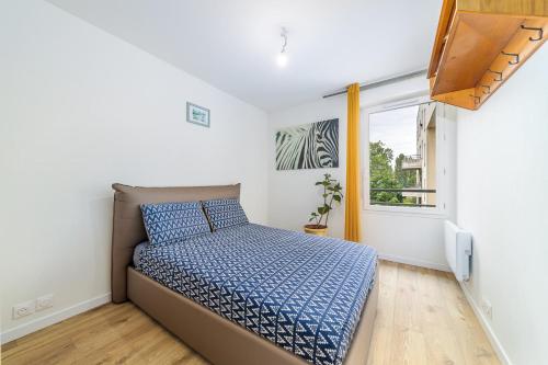 a small bedroom with a bed and a window at Escapade du Stade BY UTA HOUSE in Saint-Denis