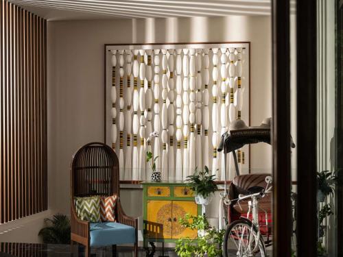 a room with a chair a table and a window at Avista Grande Phuket Karon - MGallery in Karon Beach