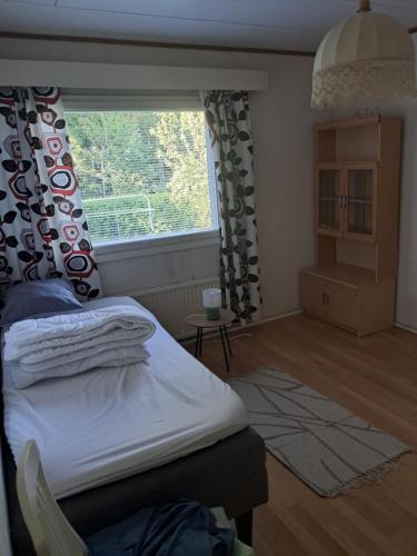 a bedroom with a bed and a large window at Jänispolku in Rauma