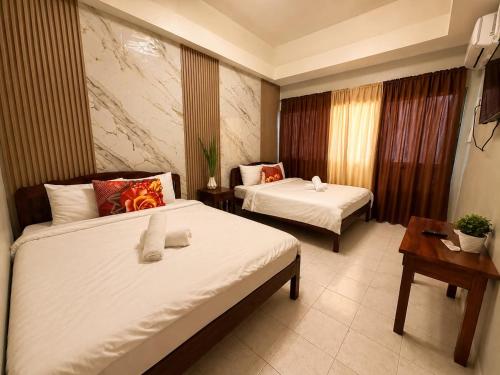 a hotel room with two beds and a table at Aloha Ocean View Resort in Pandan