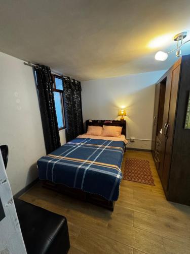a bedroom with a bed with a blue blanket at Monoambiente 101 in Trujillo